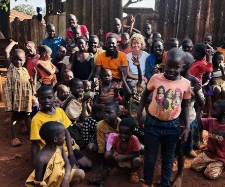 Großes Gruppenbild mit Dutzenden Kindern und Mitarbeitenden auf dem Gelände.